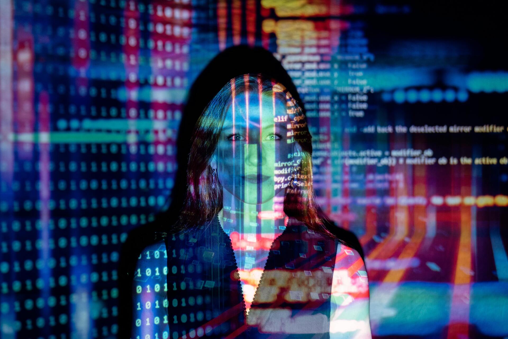 Close up of hands typing on a laptop with code on screen